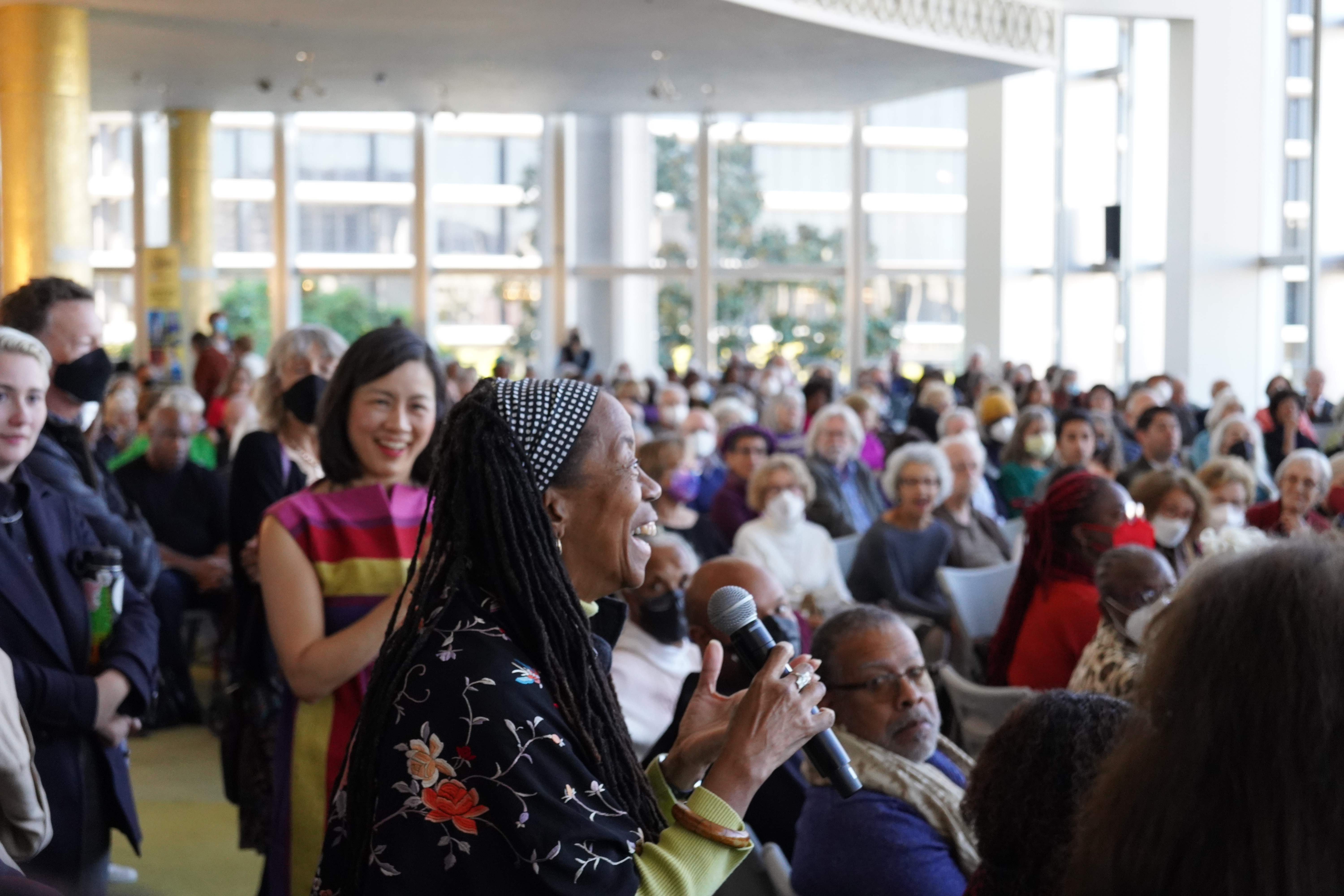 An opera-goer excitedly holding a microphone asking a question at a pre-performance talk. at