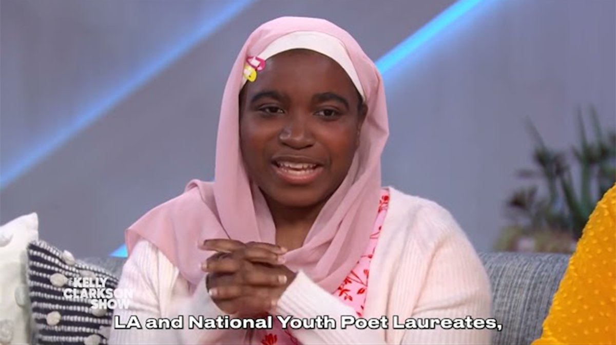 A woman in a pink sweater and head-covering with hands clasps, smiling at the camera. Text reads LA and National Youth Poet Laureates.